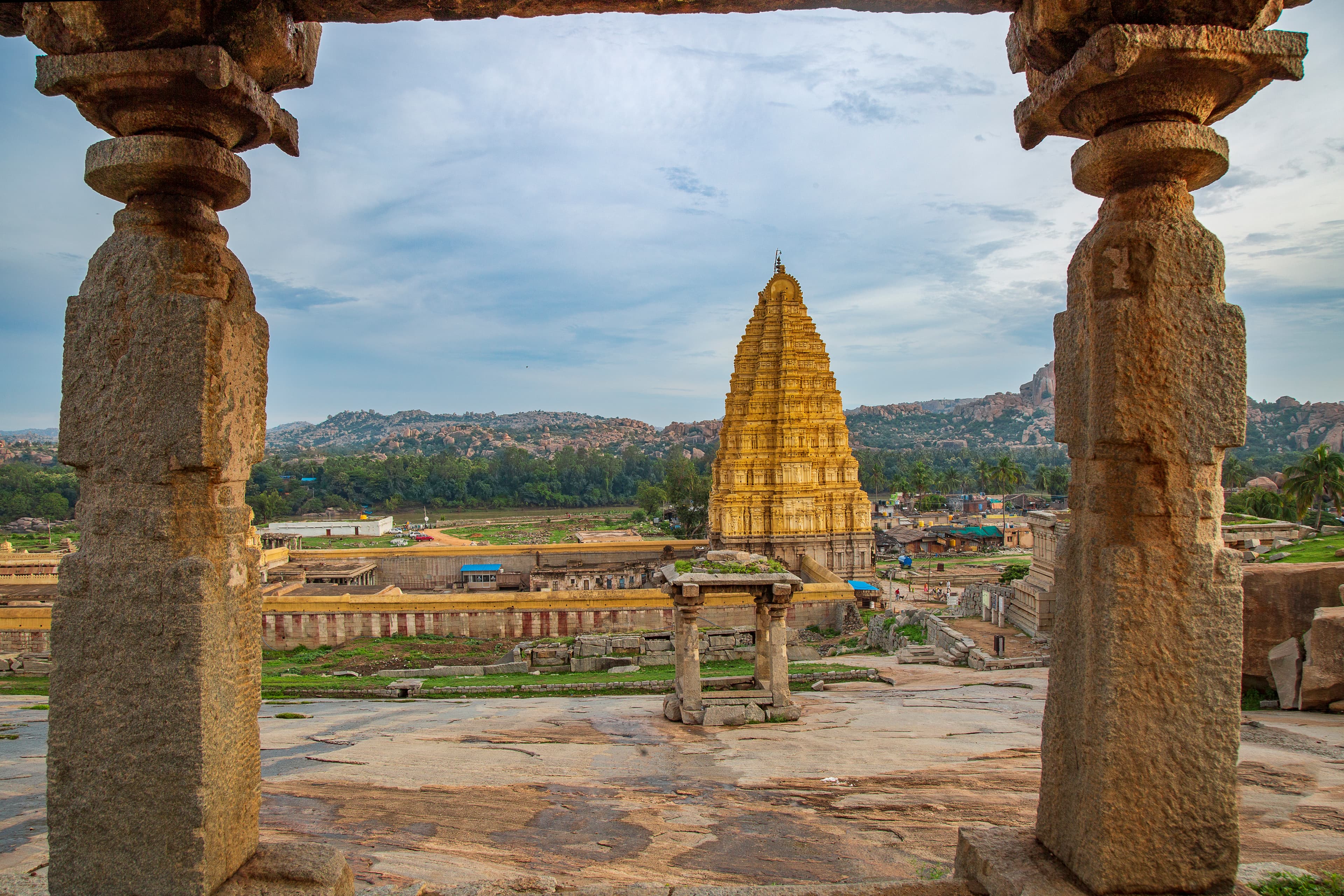 Framed by Time Virupaksha Temple Through the Stone Pillars of Hemkuta