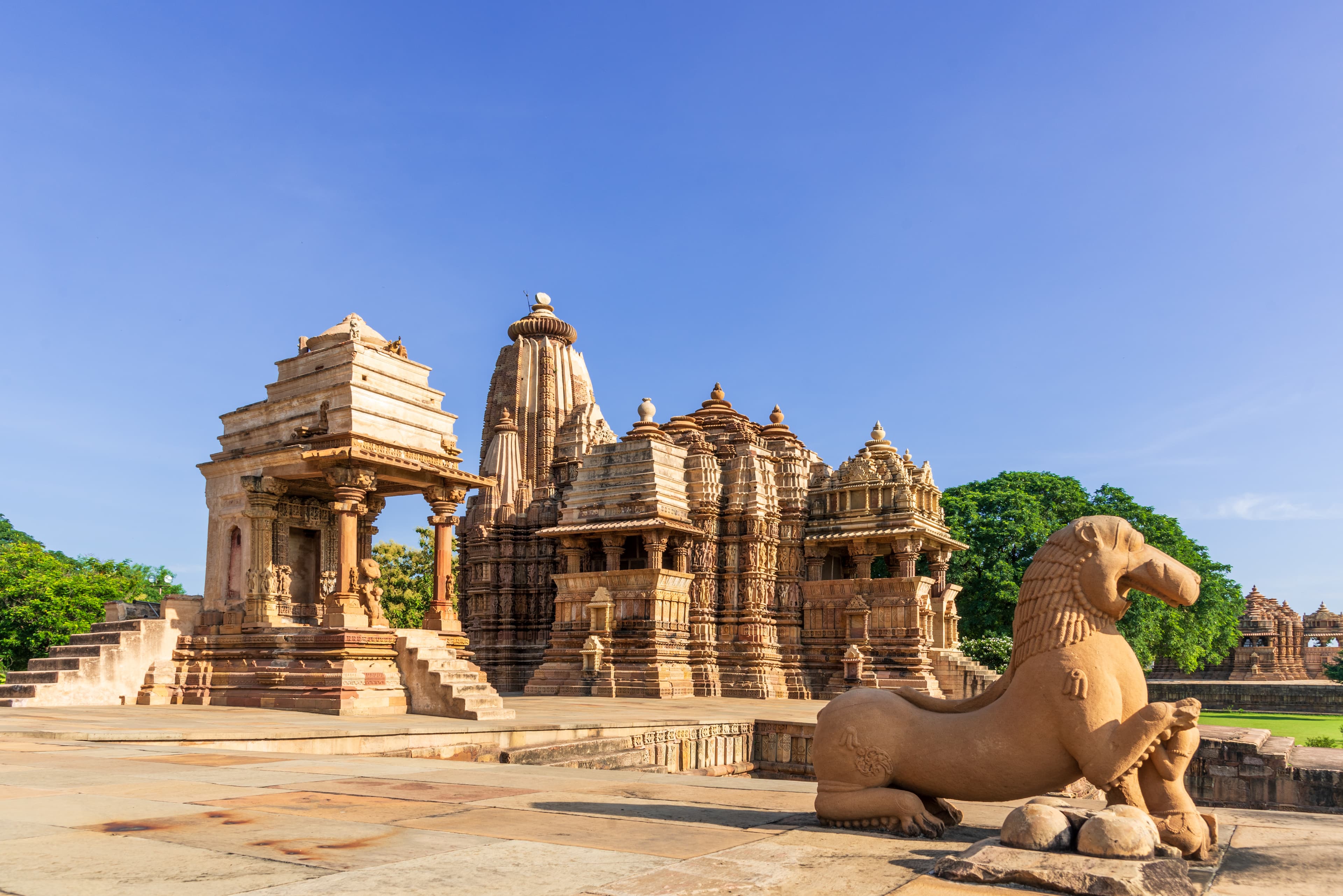 Sunlit Khajuraho Temple Complex with Guardian Lion Sculpture