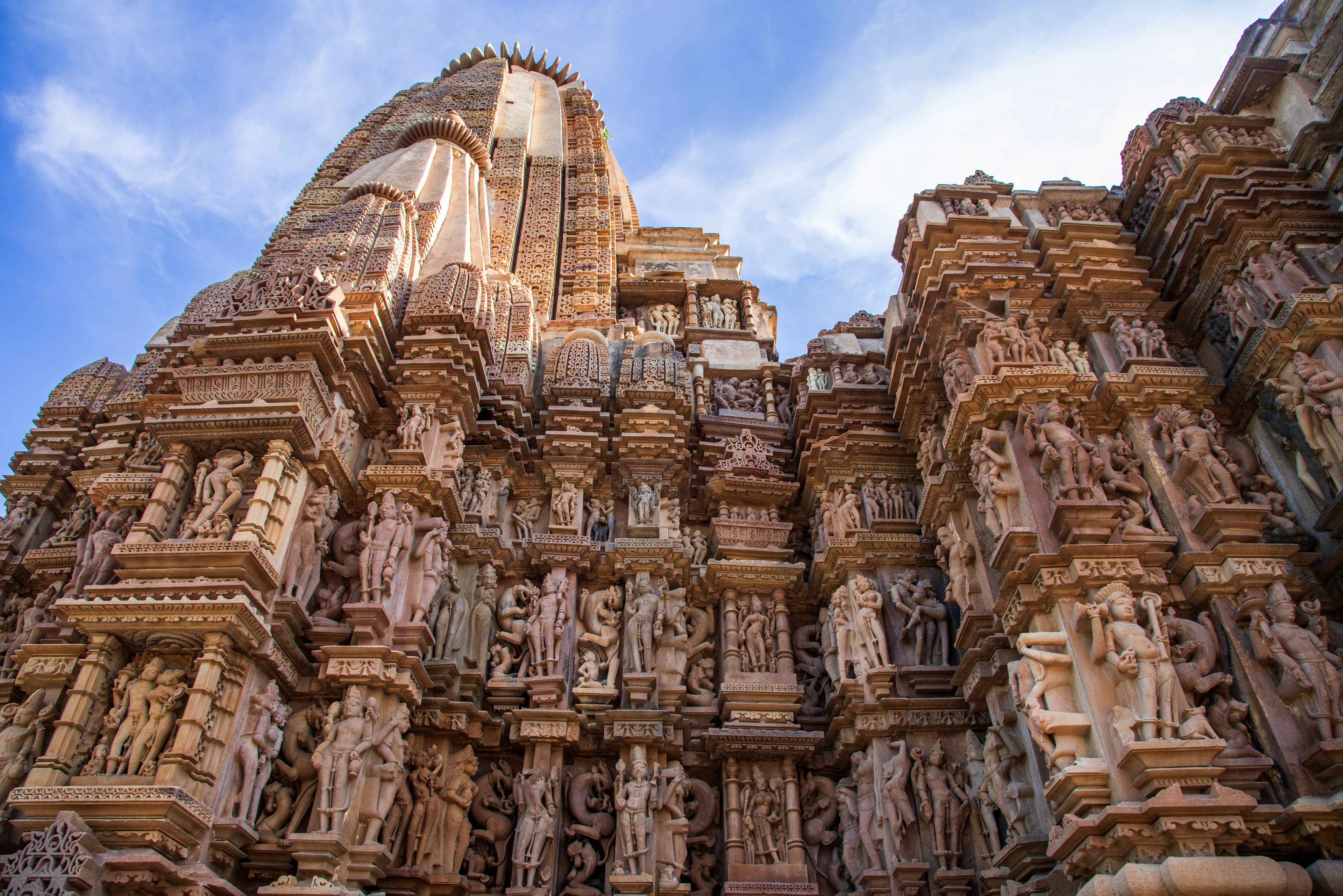 Ornate Khajuraho Temple Wall with Mythological Sculptures Under Clear Sky
